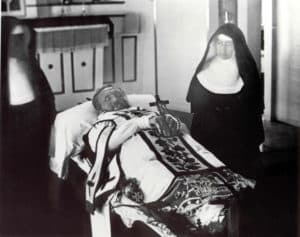 Father Damien on his funeral bier with Mother Marianne Cope by his side